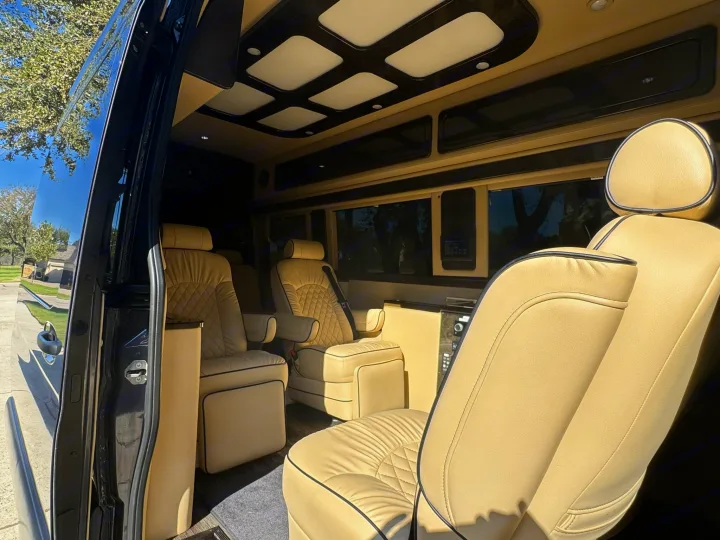 Plush beige seating and custom lighting define this luxurious RV rental's interior, offering ultimate comfort for your travels.. Midwest Automotive Designs Ultimate Presidential 2020