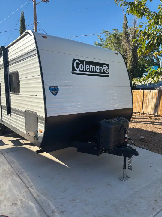This white & black Coleman travel trailer is perfect for your next RV rental. Note its front hitch and propane tanks.. Coleman Coleman 23 B 2025