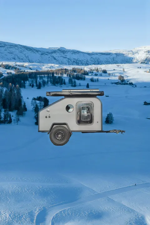 Off-road RV rental camper seemingly floats above a vast, snowy mountain landscape, perfect for winter adventures.. Campworks NS-1 Electrified 2024