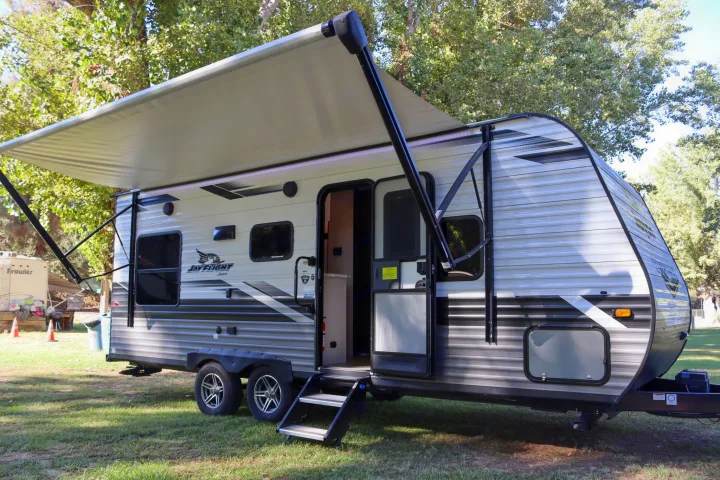 Spacious Jay Flight travel trailer rv rental parked on grass with awning extended and steps down, ready for adventure.. Jayco Jay Flight SLX Rocky Mountain Edition 2022