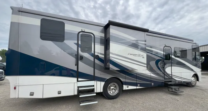 This large, modern grey, blue & white motorhome with geometric graphics is ready for your next rv rental adventure.. Newmar Canyon Star 2021