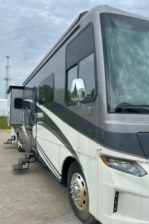 Modern RV rental, a grey & white motorhome with extended slide-out, deployed steps, and "Interior Staging Photos" on windshield.. Newmar Canyon Star 2021