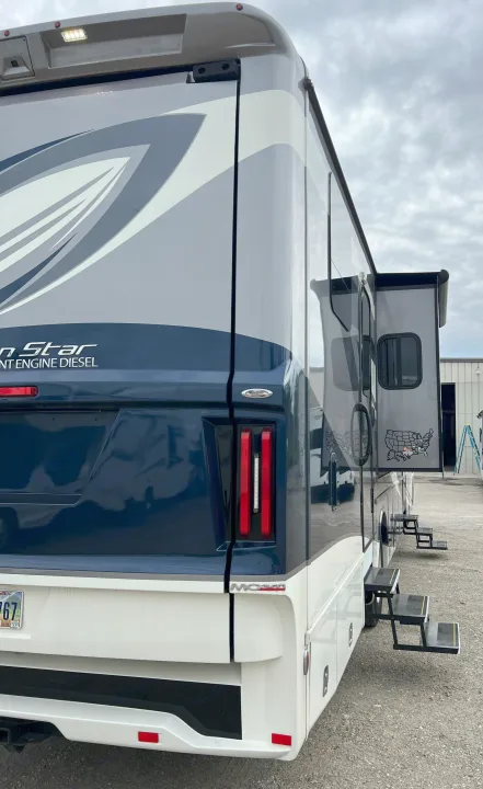 Large, gray and blue Newmar motorhome RV rental, featuring an extended slide-out and steps for easy access.. Newmar Canyon Star 2021