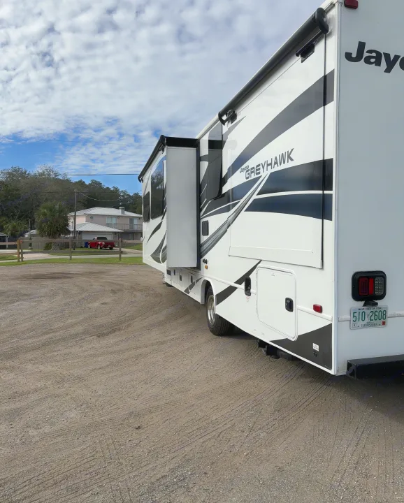 Spacious Jayco Greyhawk RV rental with extended slide-out, parked on a gravel lot under a cloudy sky, ready for adventure.. Jayco Greyhawk 2022