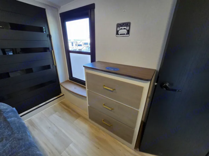Cozy RV rental bedroom with dresser, window seat, and wall sign indicating handy bedside outlets.. Forest River Hemisphere 2025