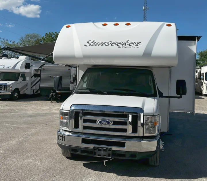 White Ford Sunseeker Class C RV, ideal for rv rental, parked outdoors under a blue sky. Ready for your next road trip.. Forest River Sunseeker 2016