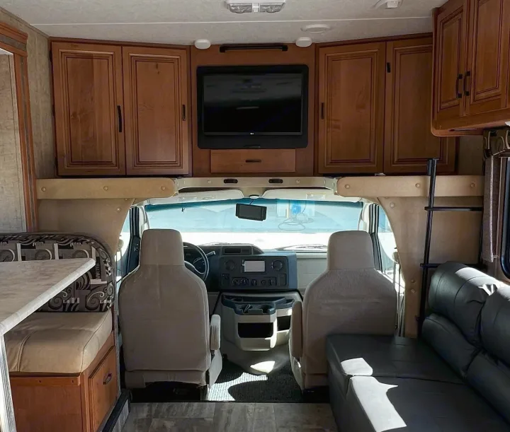 RV rental: Inside a motorhome looking forward at the cockpit, living area, and overhead bed/storage.. Forest River Sunseeker 2016