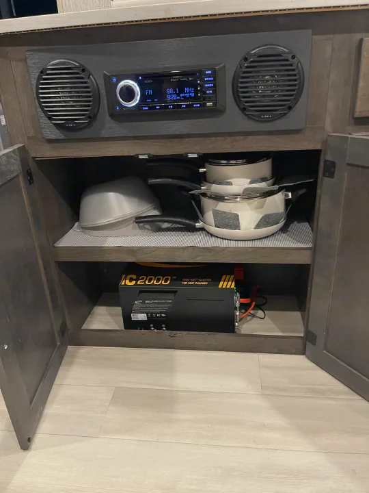 RV rental cabinet features Jensen stereo, organized kitchen pots, and a Go Power! IC 2000 inverter/charger.. Forest River Coachmen Leprechaun Premier 2022