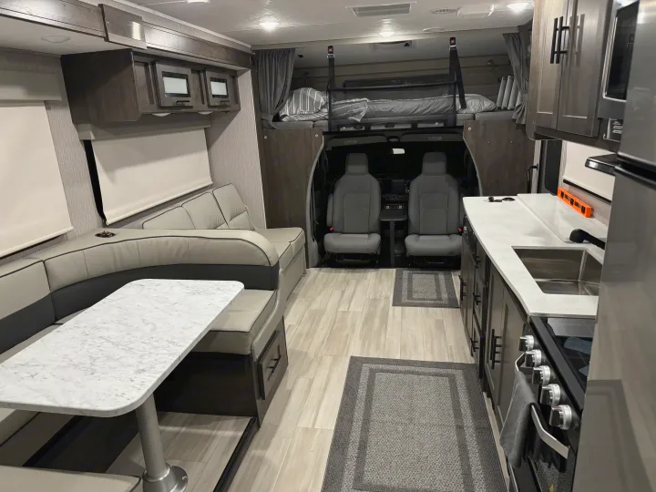 Spacious RV rental interior with modern kitchen, U-shaped dinette, and cab-over bunk.. Forest River Coachmen Leprechaun Premier 2022