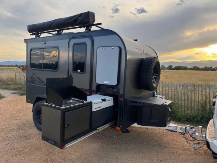 This RV rental camper features an outdoor kitchen, rooftop awning, and rugged tires, perfect for your next outdoor adventure.. InTech RV Flyer 2023