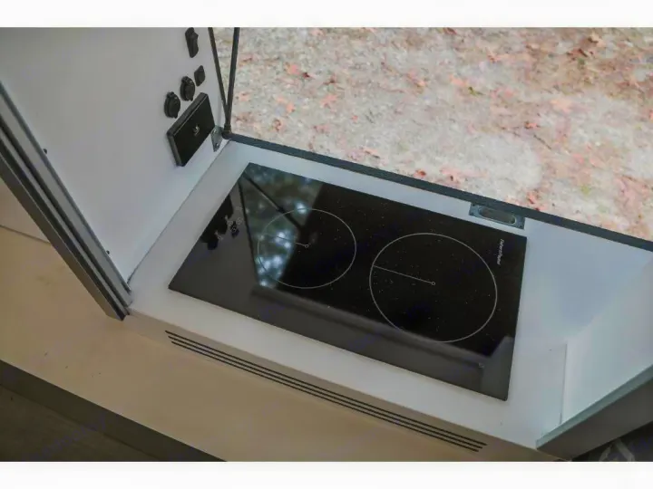 An RV rental's compact kitchenette features a two-burner induction cooktop and accessible power ports.. Bruder EXP-6 2018