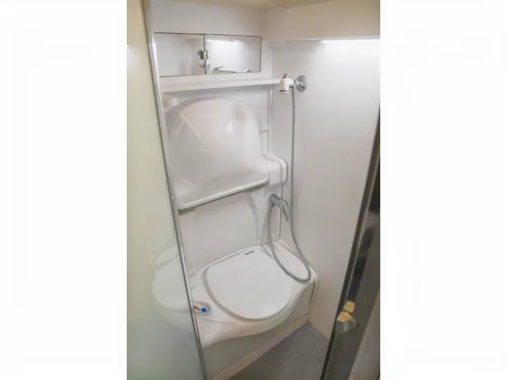 Inside an RV rental: a modern, compact bathroom featuring a toilet, pull-down sink, and shower for convenience.. Bruder EXP-6 2018