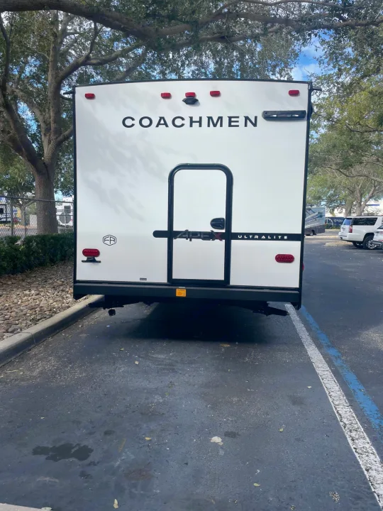 Rear view of a white Coachmen Apex Ultralite RV, ideal for an RV rental, parked on asphalt.. Coachmen APEX 284BHSS 2025