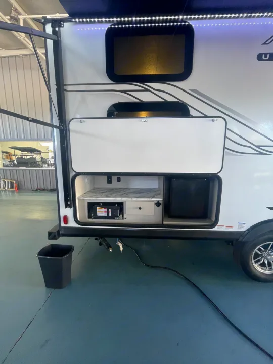 Outdoor kitchen setup on an RV rental, featuring a fridge, counter, and power access for easy outdoor living.. Coachmen Apex 245 BHS 2025