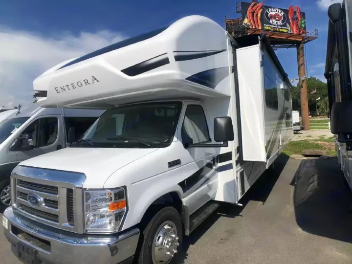 A white Entegra Class C motorhome on a Ford chassis, with an extended slide-out. Ready for your rv rental adventure.. Entegra Coach Odyssey 2024