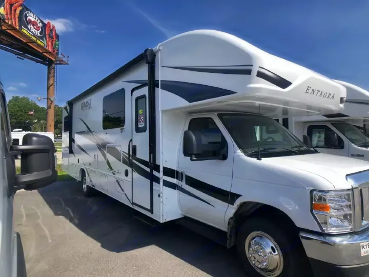 White Entegra Odyssey Class C RV motorhome available for rental, parked on pavement under a clear blue sky.. Entegra Coach Odyssey 2024