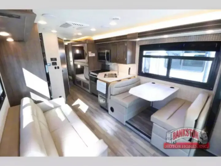 Spacious RV rental interior with living area sofa, full kitchen, cozy dinette, and bunk beds.. Entegra Coach Odyssey 2024