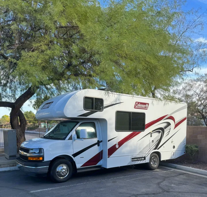 White Coleman RV rental parked under a large tree, ready for adventure.. Thor Coleman 2024