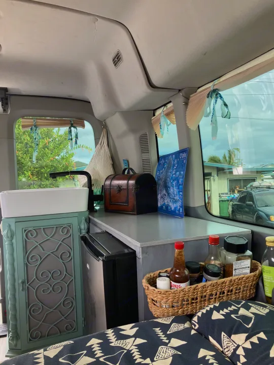 Custom RV rental camper van interior featuring a sink, mini-fridge, and kitchen essentials, ready for travel.. Ford Transit 2018