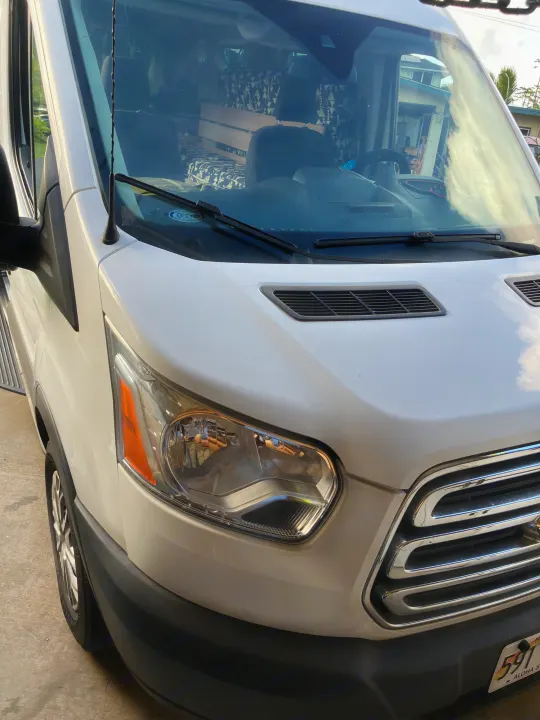 Front view of a white Ford Transit van, converted into an RV rental, with visible interior setup.. Ford Transit 2018