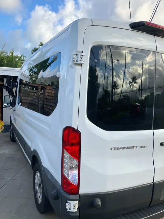 White Ford Transit 350 van, ideal for your next RV rental adventure. Parked with tropical reflections.. Ford Transit 2018