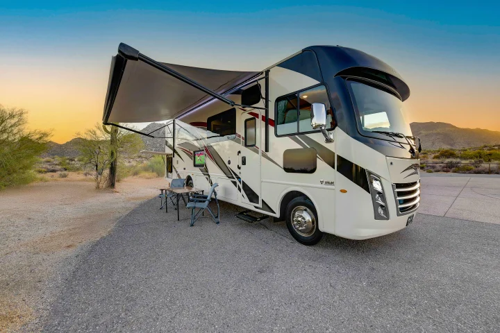 This RV rental offers a perfect desert getaway. An outdoor TV, awning, and seating invite relaxation at sunset.. Thor A.C.E. 2022