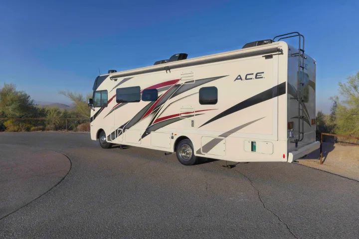 This white A.C.E. motorhome rv rental is ready for adventure, parked on asphalt with desert views.. Thor A.C.E. 2022