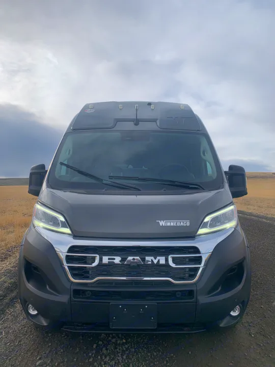 Front view of a grey Winnebago RV rental on a dirt road, ideal for scenic road trips.. Winnebago Solis 59PX 2025