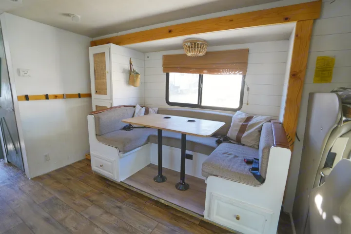 Cozy renovated RV rental interior featuring a comfortable U-shaped dinette, wood accents, and modern finishes.. Jamboree Sport 2011