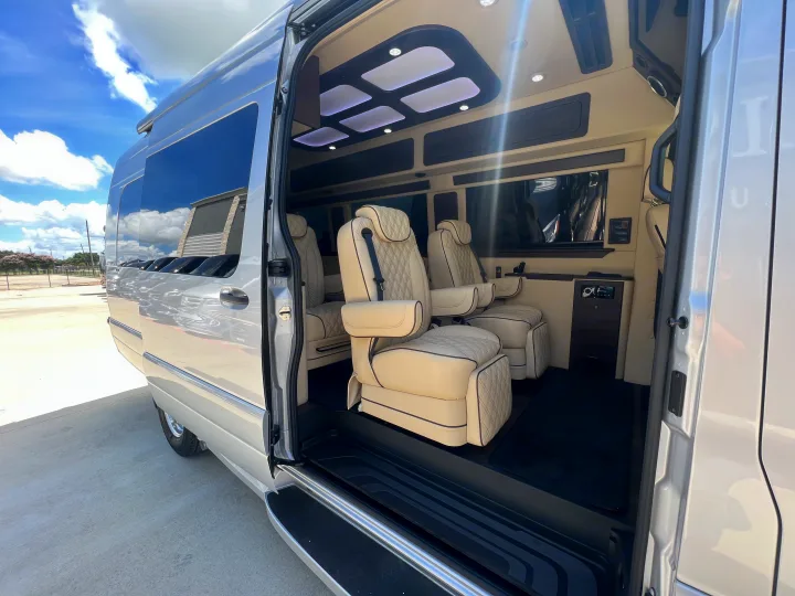 Experience a luxury RV rental. This spacious van's interior features cream, quilted seats, ambient lighting, and dark wood accents.. Midwest Automotive Designs Day Cruiser 2024