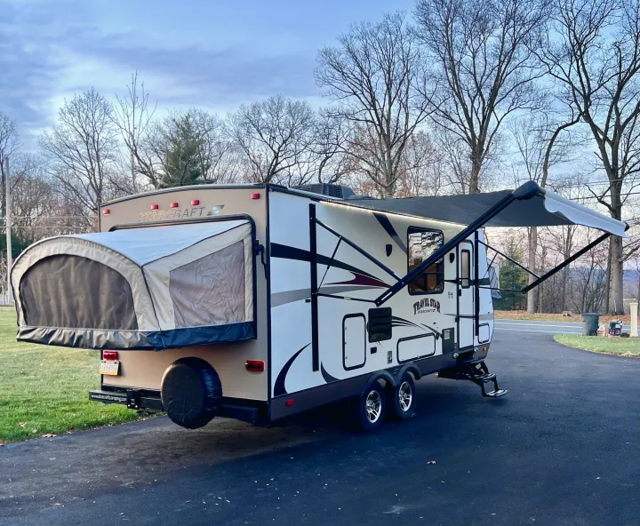 RV rental ready! A modern Starcraft travel trailer with pop-out and extended awning parked on a driveway.. Starcraft Travel Star 2015