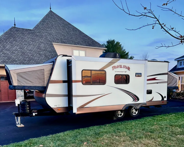 Travel Star hybrid RV rental parked in a driveway, its pop-out beds extended for a spacious, comfortable stay.. Starcraft Travel Star 2015