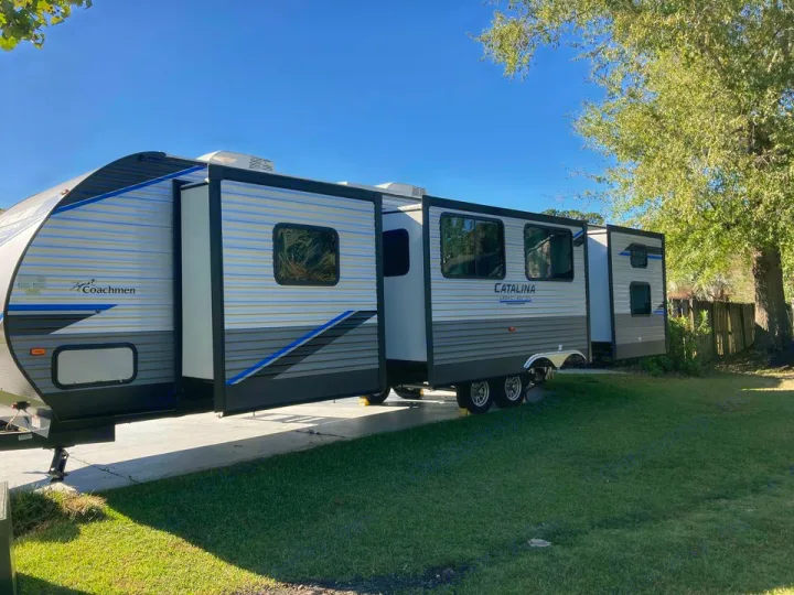 Spacious Coachmen Catalina travel trailer with slide-outs extended, ready for an RV rental outdoor adventure or camping.. Coachmen Catalina 2022
