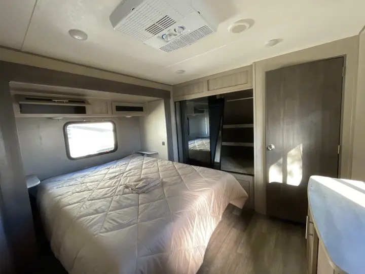 Bright and functional RV rental bedroom featuring a cozy bed, ample storage, and built-in AC unit, ready for your next adventure.. Coachmen Catalina 2022