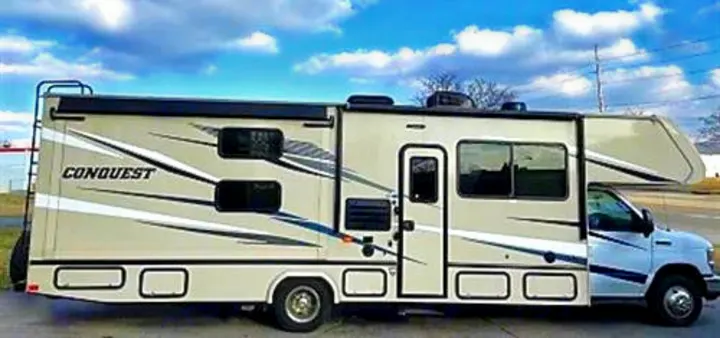 Light tan Class C **RV rental**, a Conquest model, with a slide-out & awning, parked outdoors. Perfect for your next adventure.. Gulf Stream Conquest 2020