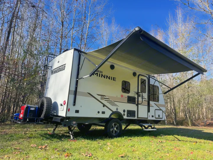 Explore the outdoors! A Winnebago Micro Minnie travel trailer, perfect for your next rv rental adventure, parked on grass.. Winnebago Minnie Winnie 2022