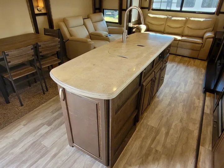 RV rental living area: Kitchen island with sink, dining table, and cozy sofa provide comfort for your travels.. Grand Design Solitude 2019
