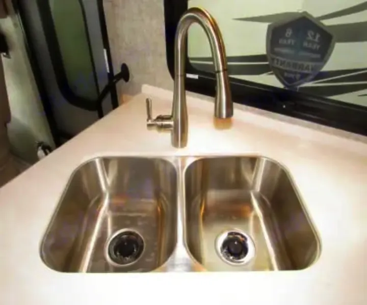 This RV rental features a clean, functional kitchen area with a double stainless steel sink and a modern gooseneck faucet.. Thor Miramar 2022