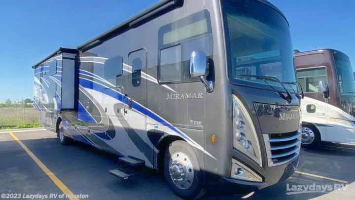 This dark gray Thor Miramar RV, with blue/white graphics, is ready for rv rental adventures.. Thor Miramar 2022