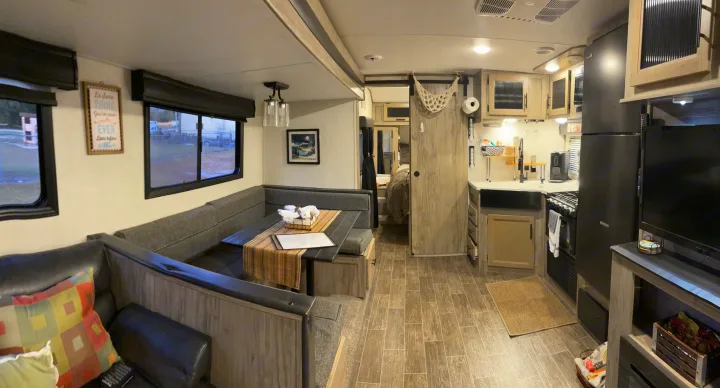 Comfortable RV living space with kitchen, dinette, and sofa area, perfect for RV rental.. Forest River Cherokee Alpha Wolf 2022