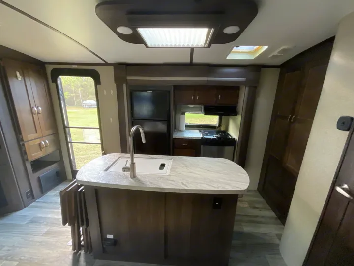 Spacious and modern RV rental interior featuring a kitchen island, full appliances, and ample cabinetry. Ideal for travel.. Keystone RV Outback Super-Lite 2018