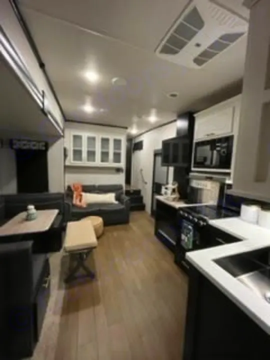 Spacious, modern RV rental interior showcasing a comfortable living area, kitchen, and dining space. Ideal for travel.. Forest River Wildcat 2022
