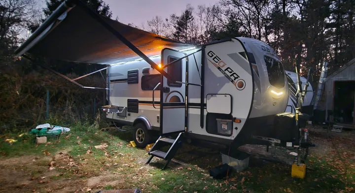 Evening glow on a Geo Pro travel trailer with an extended, lit awning. Ideal for your next rv rental adventure.. Forest River Rockwood Geo Pro 2022
