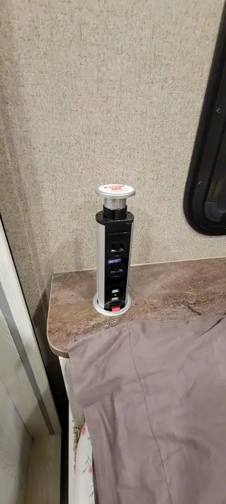 Modern pop-up power outlet tower with AC/USB ports in an RV rental, providing convenient charging on the countertop.. Forest River Rockwood Geo Pro 2022
