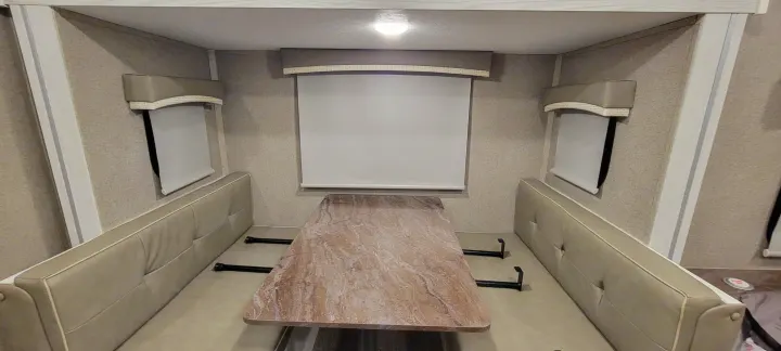 RV rental interior: functional dinette with comfortable bench seating, table, and pull-down window shades.. Forest River Rockwood Geo Pro 2022
