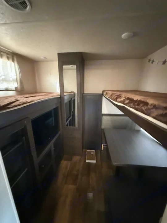 Explore this RV rental's bunkhouse layout featuring multiple bunk beds, a built-in TV, and a dinette area.. Forest River Salem 2019