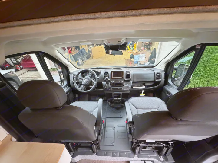 Front cabin view of an RV rental van, showing the dashboard, steering wheel, and comfortable seats. Ideal for road trips!. Dave & Matt Vans Dave & Matt Vans Class B 2024