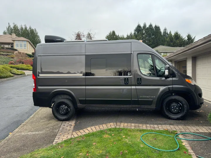 Dark gray camper van with rooftop AC, ideal for RV rental and road trips. Side text: DAVE & MATT VANS.. Dave & Matt Vans Dave & Matt Vans Class B 2024