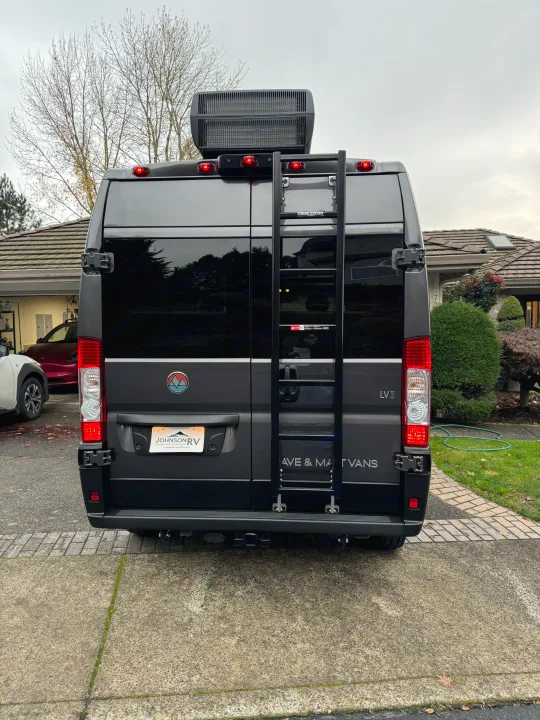 Rear view of a grey camper van with a roof AC unit and ladder, featuring custom branding. Great for an rv rental.. Dave & Matt Vans Dave & Matt Vans Class B 2024