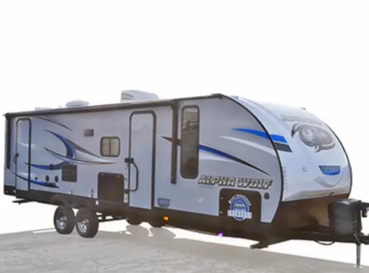 A sleek grey and blue Alpha Wolf travel trailer, ideal for your next RV rental and outdoor adventure.. Forest River Cherokee Alpha Wolf 2018